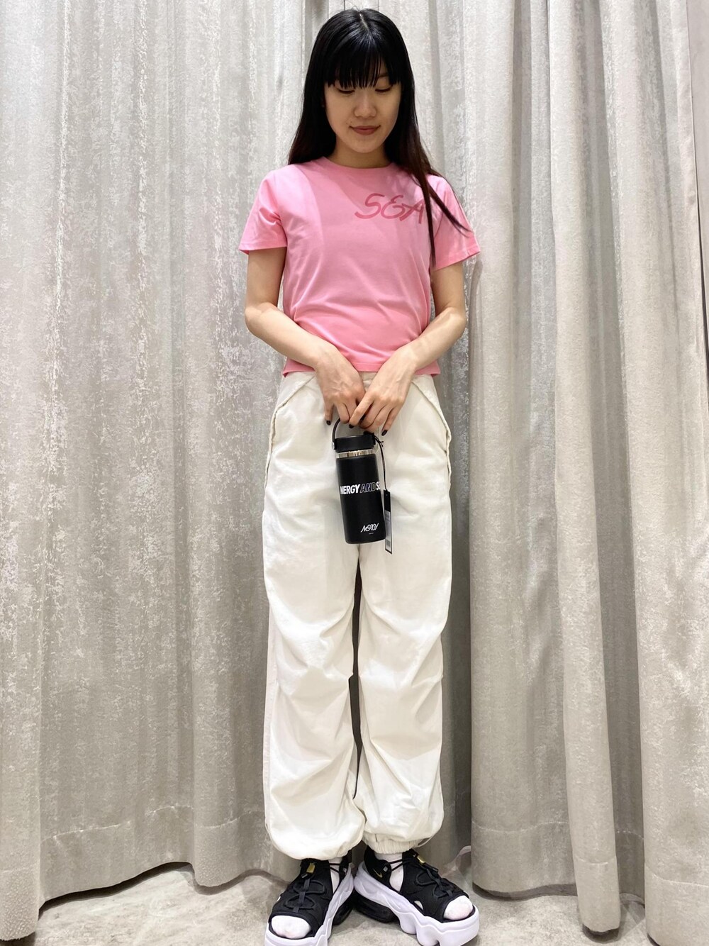 ホワイト系のその他パンツ、ブラック系のサンダル、ピンク系のTシャツ/カットソーを着用したレディースの春コーディネートの1枚目の写真