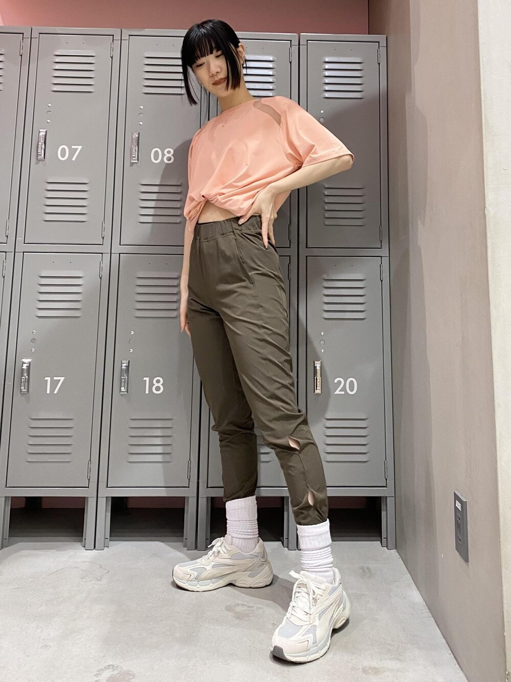 ピンク系のTシャツ/カットソー、ブラウン系のその他パンツ、ベージュ系のスニーカーを着用したレディースの春コーディネートの1枚目の写真