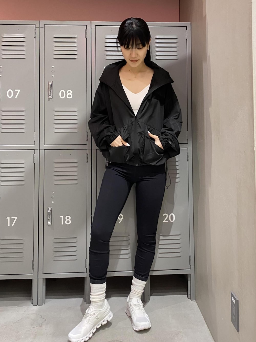 ホワイト系のスニーカー、ブラック系のブルゾン、ホワイト系のブラジャーを着用したレディースの春コーディネートの1枚目の写真