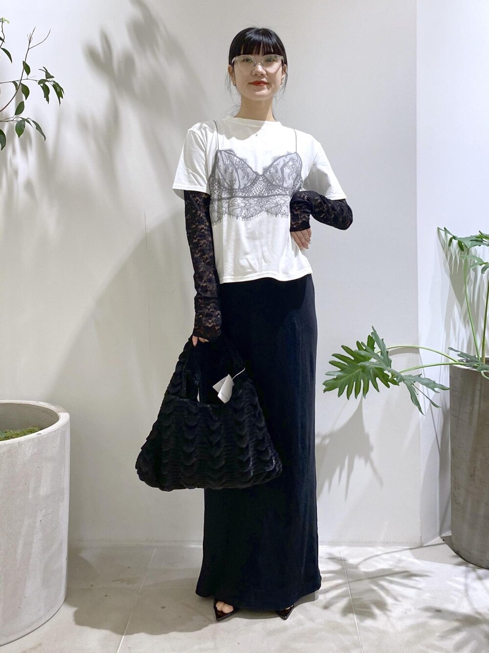 ブラック系のハンドバッグ、ブラック系のサンダル、ブラック系のスカートを着用したレディースの夏コーディネートの1枚目の写真