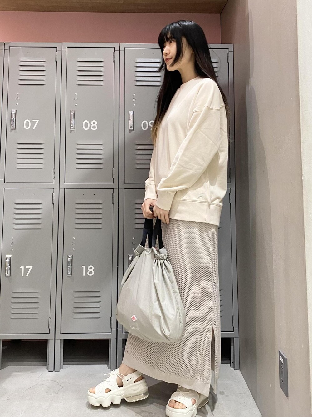 シルバー系のスカート、ホワイト系のサンダル、ベージュ系のスウェットを着用したレディースの春コーディネートの1枚目の写真