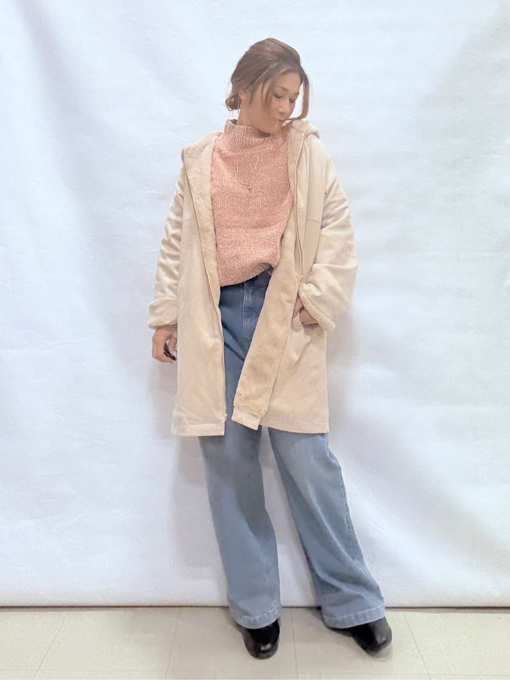 ホワイト系のその他アウター、ピンク系のニット/セーター、ブルー系のデニムパンツを着用したレディースの冬コーディネートの1枚目の写真