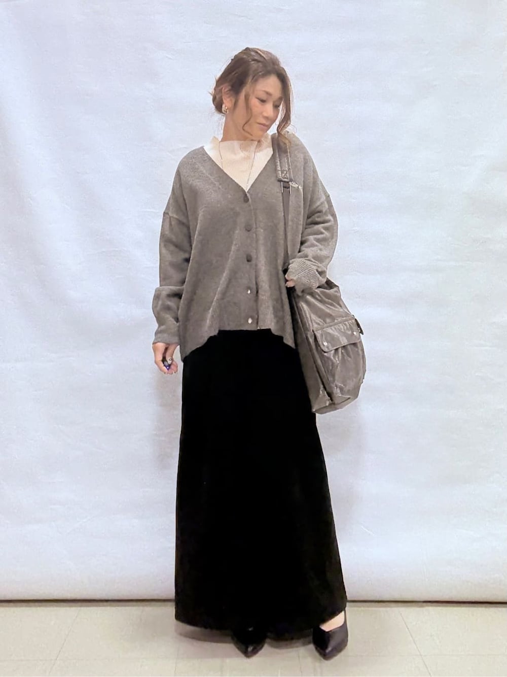 グレー系のカーディガン/ボレロ、ホワイト系のニット/セーター、ブラック系のその他パンツを着用したレディースの冬コーディネートの1枚目の写真