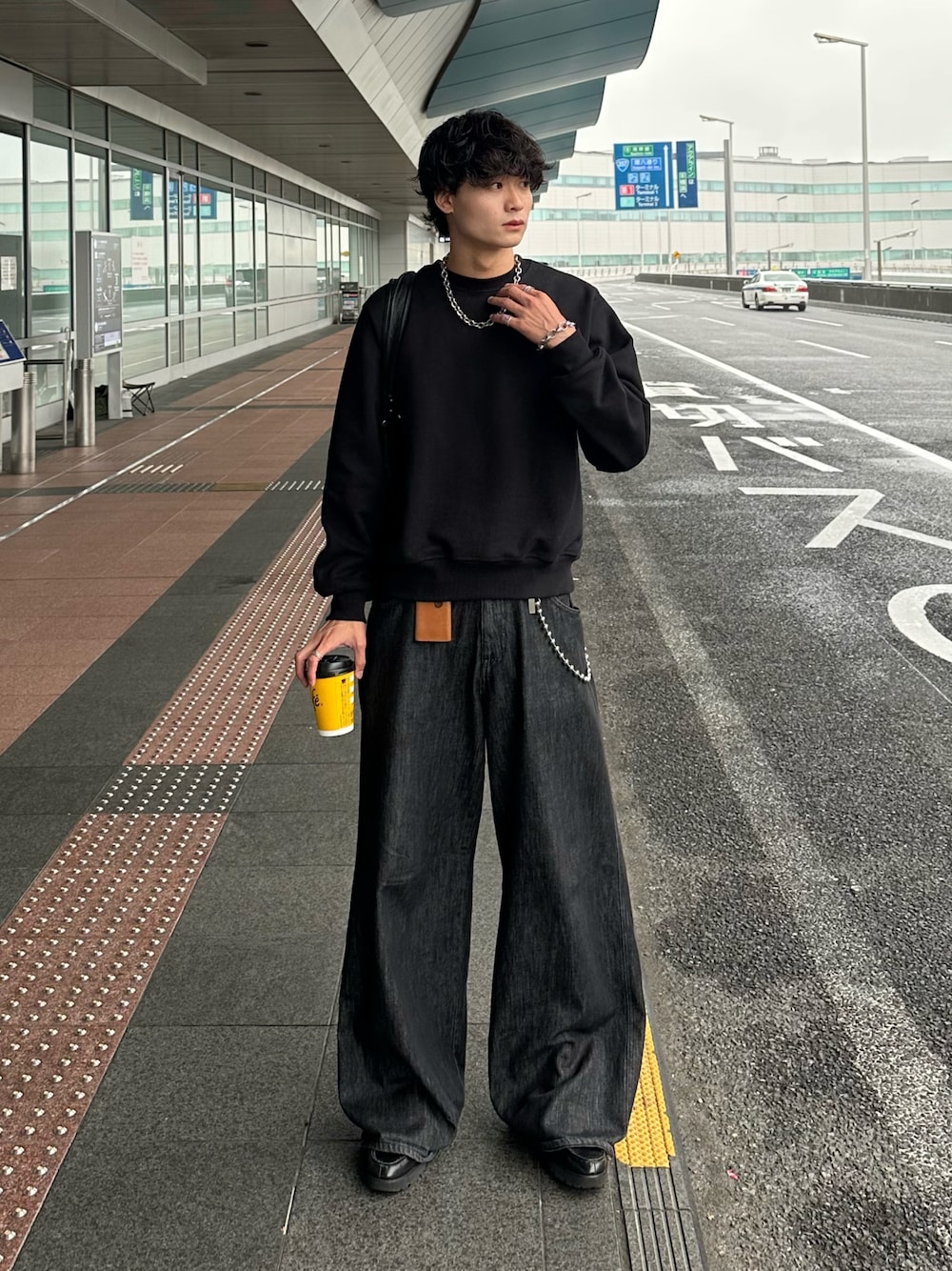 ブラック系のデニムパンツ、ブラック系のスウェット、ブラック系のローファーを着用したメンズの秋コーディネートの1枚目の写真