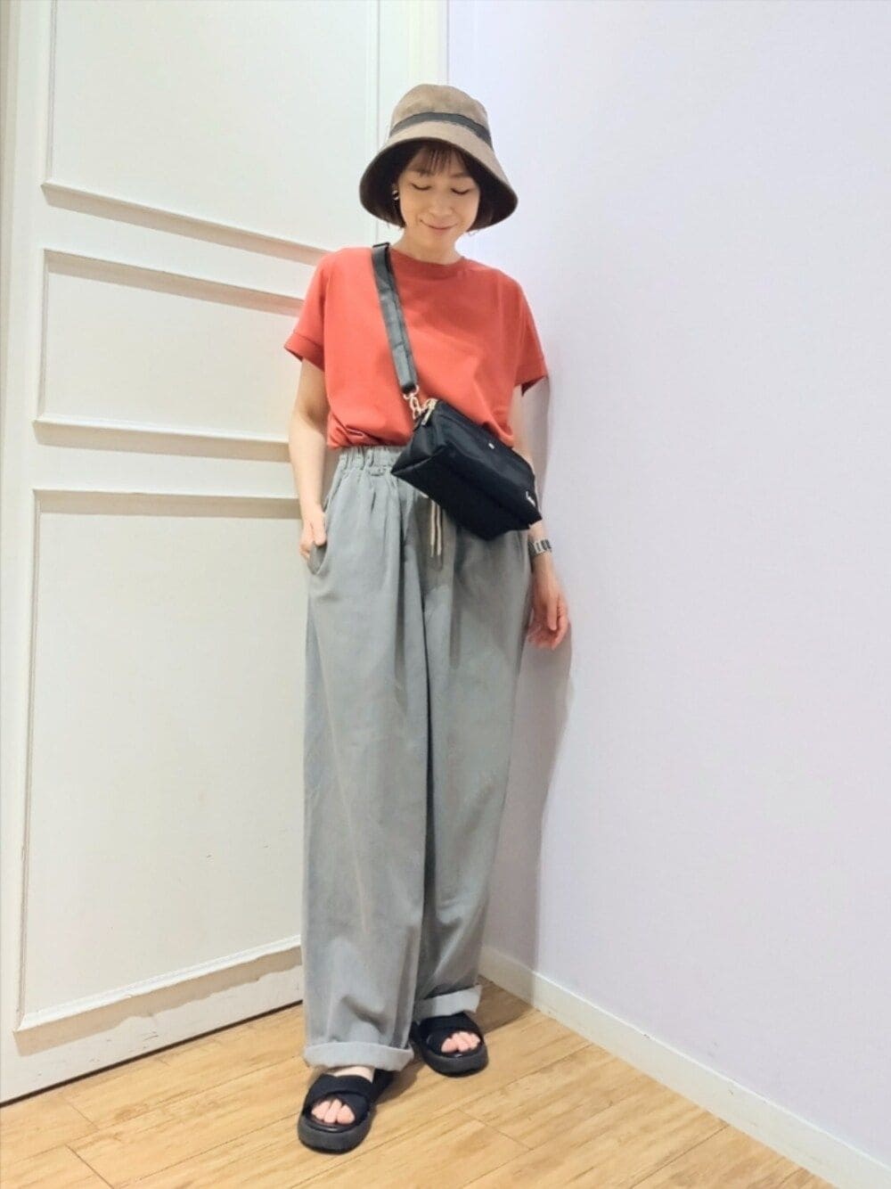 レッド系のTシャツ/カットソー、ブラック系のショルダーバッグ、グレー系のその他パンツを着用したレディースの夏コーディネートの1枚目の写真