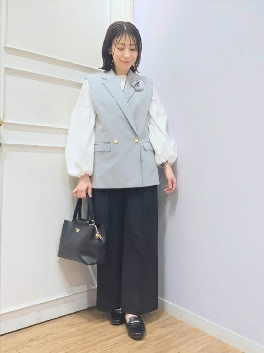 グレー系のベスト、ホワイト系のシャツ/ブラウス、ブラック系のその他パンツを着用したレディースの冬コーディネートの1枚目の写真