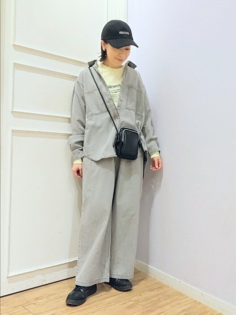 グレー系のシャツ/ブラウス、イエロー系のTシャツ/カットソー、ブラック系のショルダーバッグを着用したレディースの春コーディネートの1枚目の写真