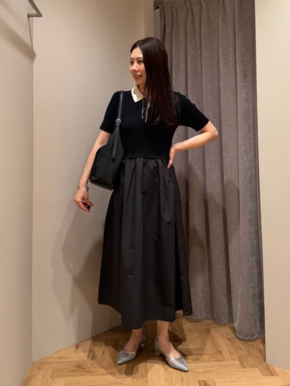 ブラック系のショルダーバッグ、ブラック系のワンピース、シルバー系のパンプスを着用したレディースの夏コーディネートの1枚目の写真