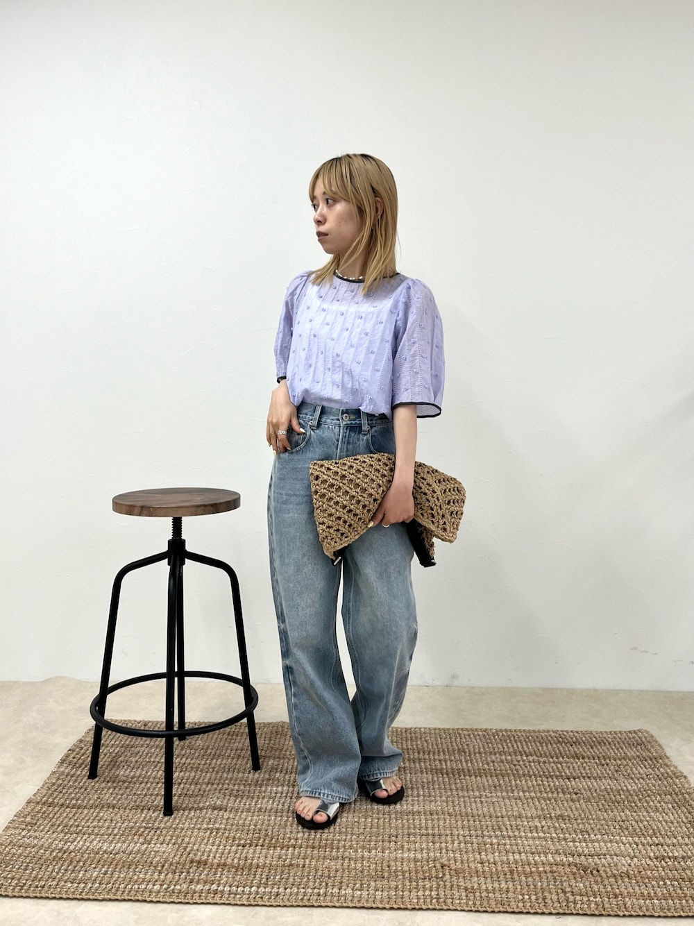 ブルー系のデニムパンツ、パープル系のシャツ/ブラウス、ベージュ系のショルダーバッグを着用したレディースの春コーディネートの1枚目の写真