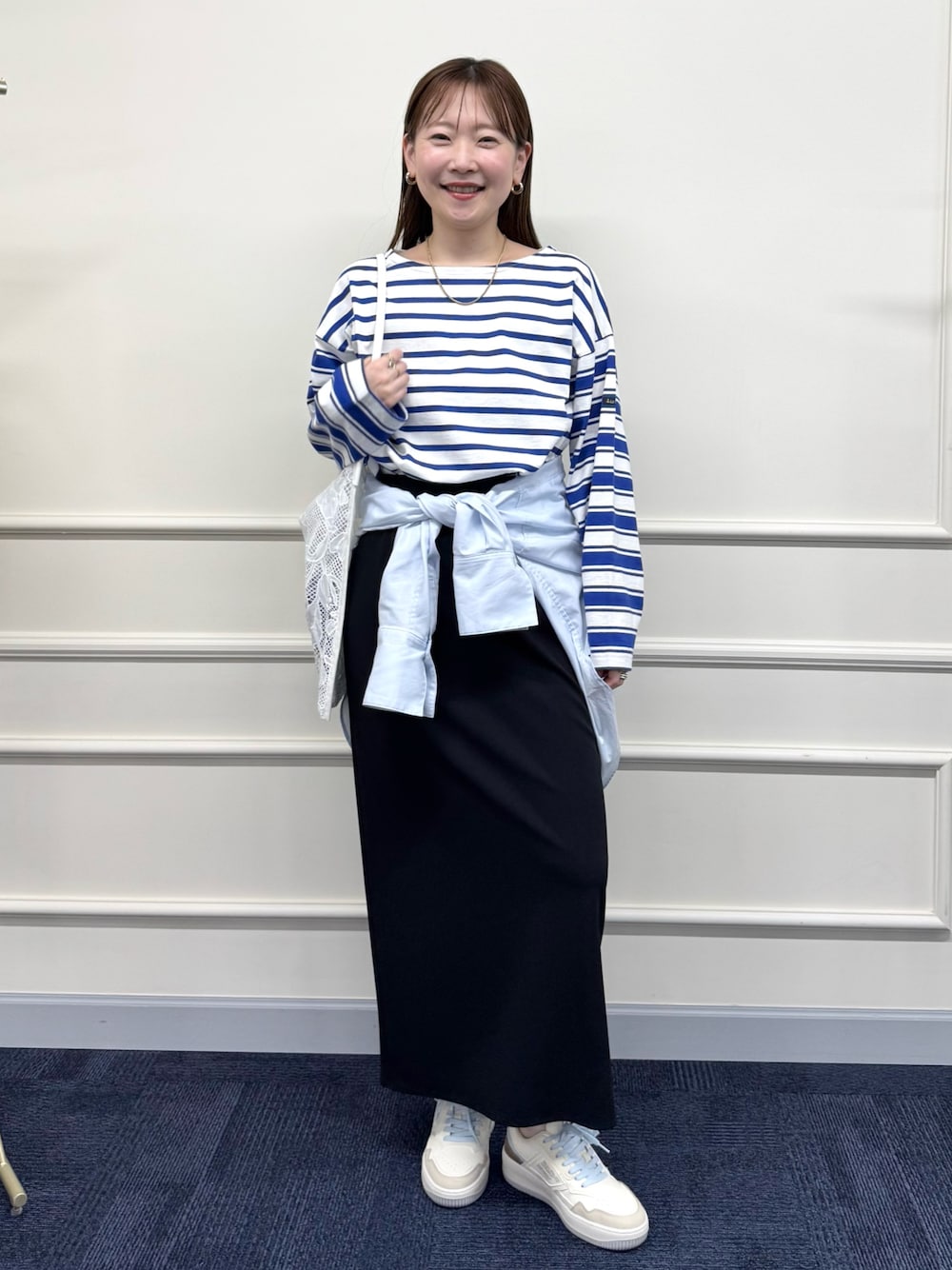 ブラック系のスカート、ブルー系のシャツ/ブラウス、ブルー系のTシャツ/カットソーを着用したレディースの春コーディネートの1枚目の写真