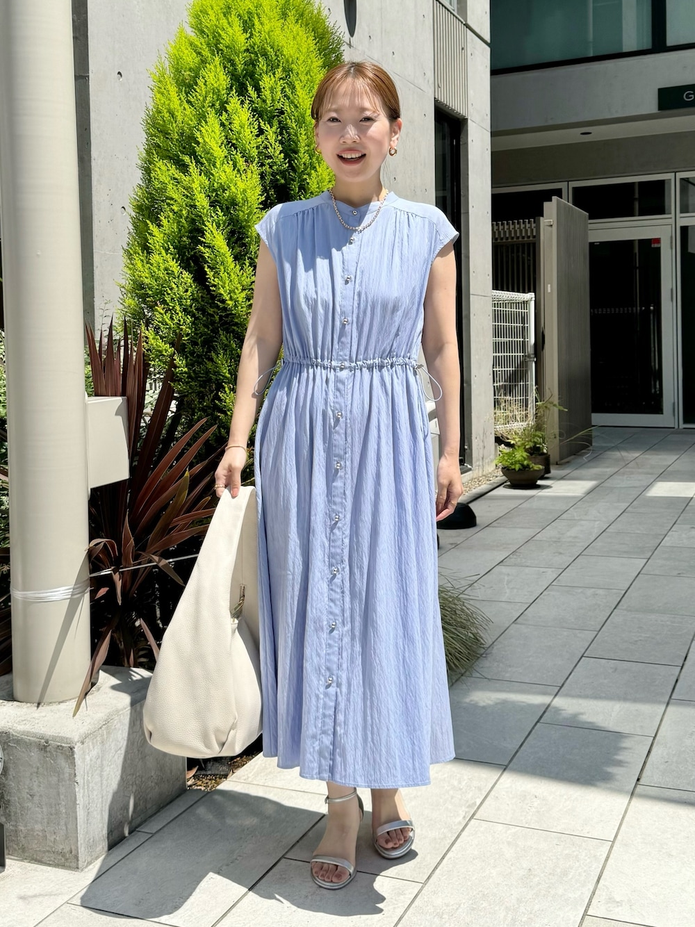 ブルー系のワンピース、ホワイト系のショルダーバッグ、シルバー系のサンダルを着用したレディースの夏コーディネートの1枚目の写真