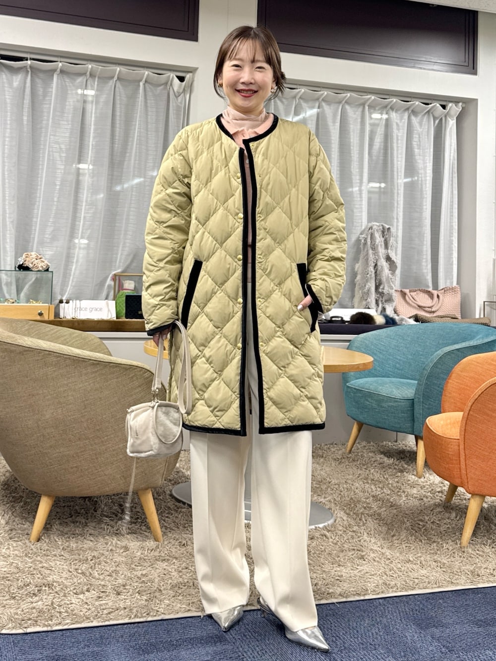 ベージュ系のショルダーバッグ、ベージュ系のダウンジャケット/コートを着用したレディースの秋コーディネートの1枚目の写真