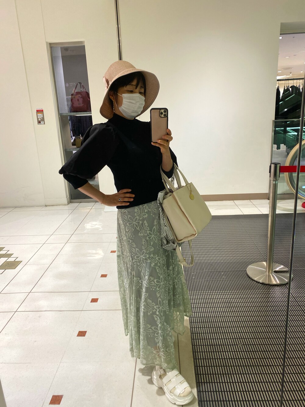 ブラック系のニット/セーター、グリーン系のスカート、ホワイト系のサンダルを着用したレディースの秋コーディネートの1枚目の写真