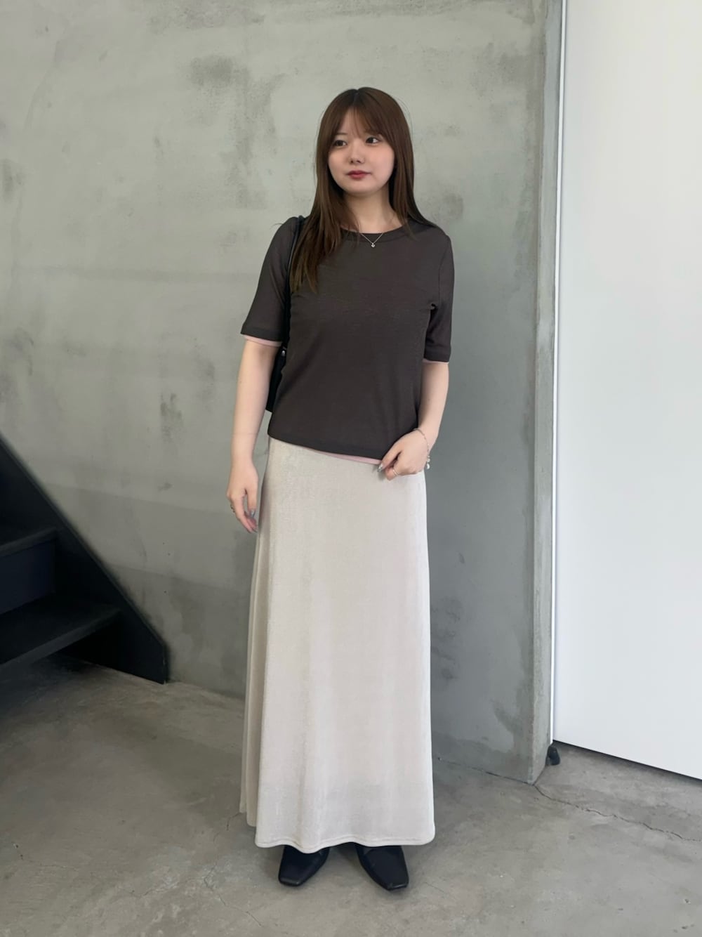 グレー系のTシャツ/カットソー、ホワイト系のスカート、ブラック系のスリッポンを着用したレディースの夏コーディネートの1枚目の写真