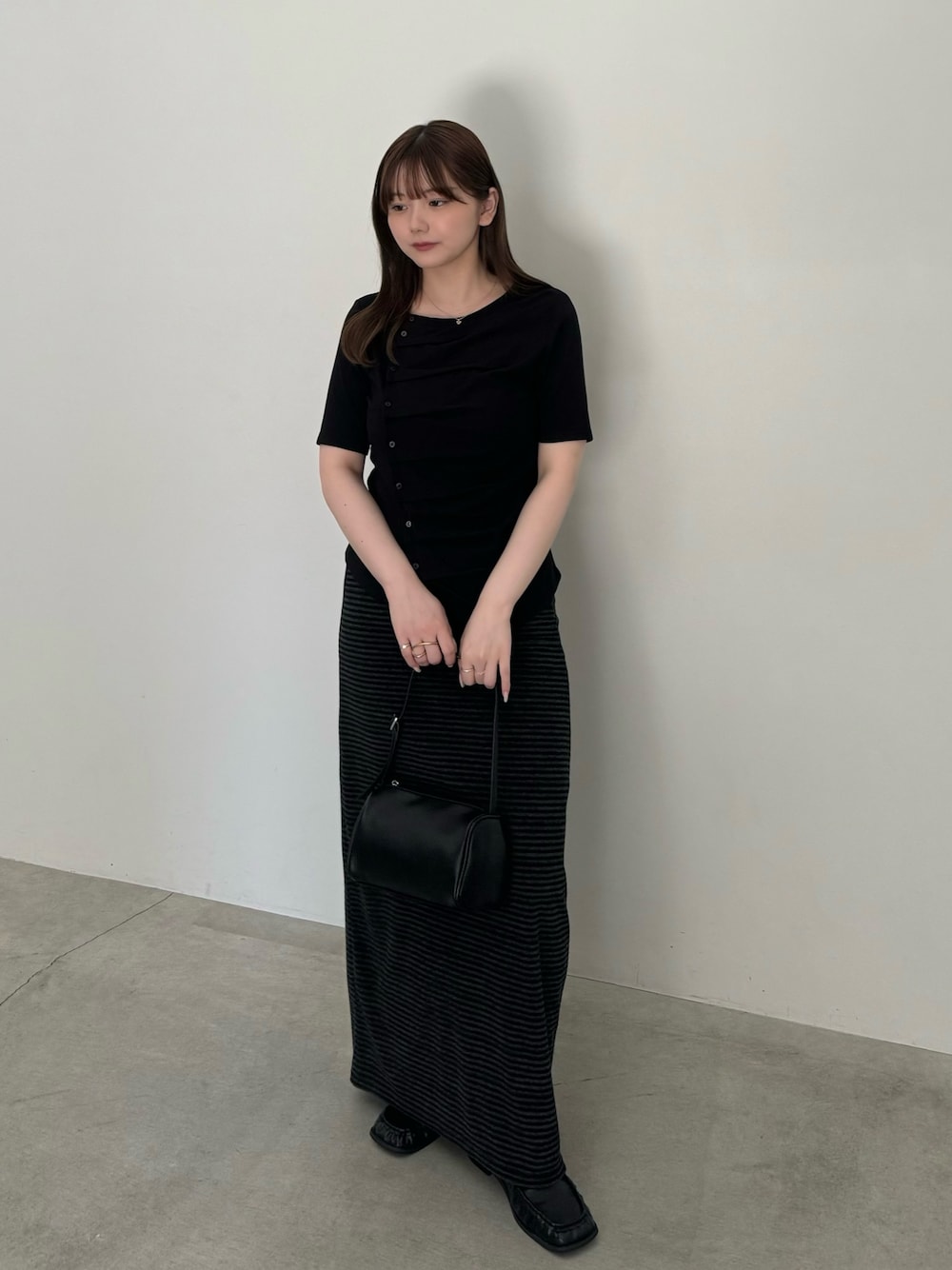 ブラック系のTシャツ/カットソー、ブラック系のハンドバッグ、ブラック系のスカートを着用したレディースの夏コーディネートの1枚目の写真