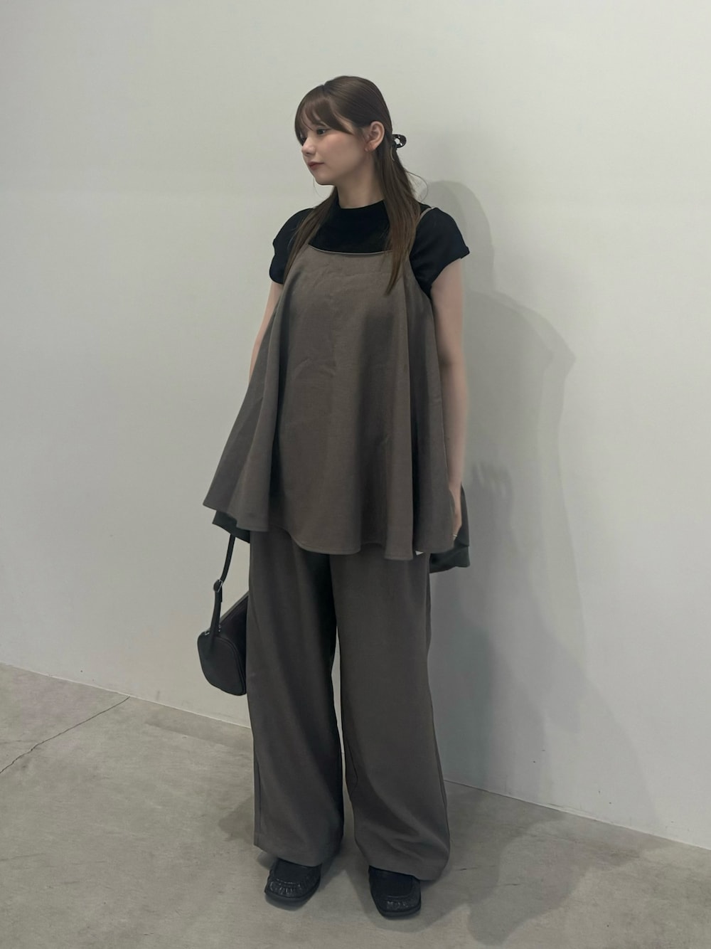 ブラウン系のキャミソール、ブラウン系のスラックス、ブラック系のTシャツ/カットソーを着用したレディースの夏コーディネートの1枚目の写真