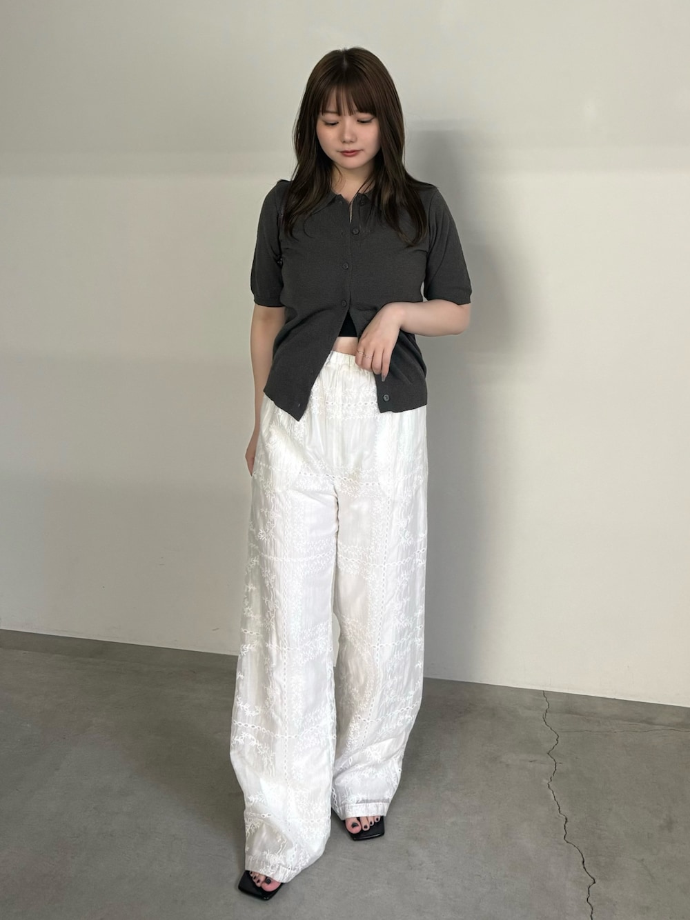 グレー系のニット/セーター、ブラック系のキャミソール、ホワイト系のその他パンツを着用したレディースの夏コーディネートの1枚目の写真