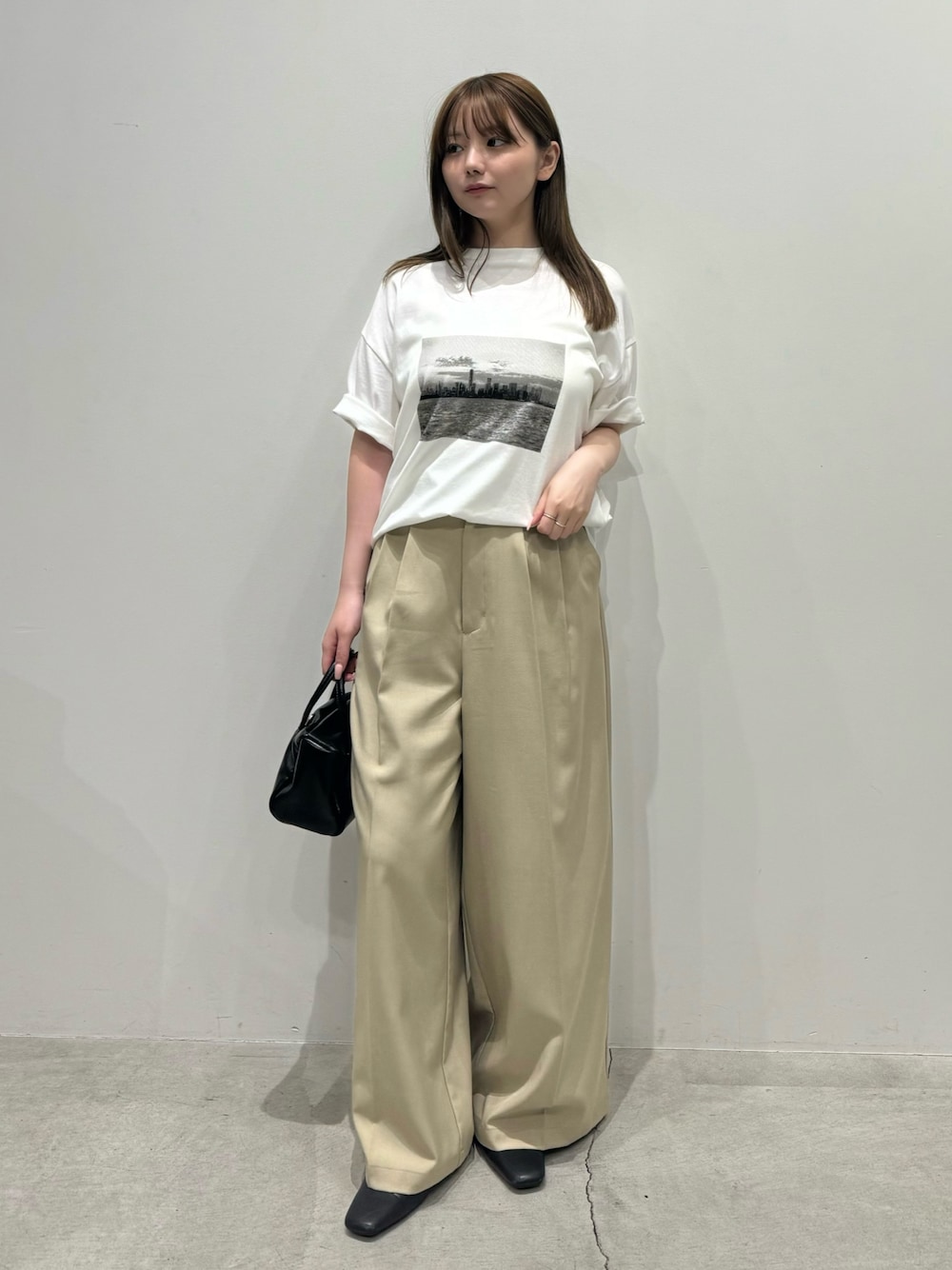 ホワイト系のTシャツ/カットソー、ベージュ系のスラックス、ブラック系のボストンバッグを着用したレディースの夏コーディネートの1枚目の写真