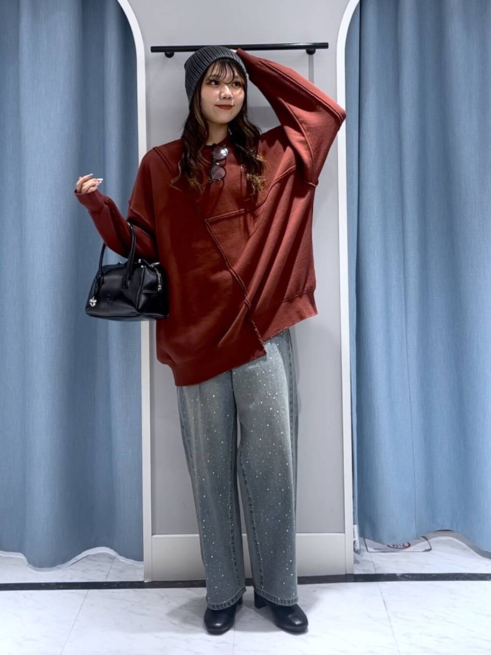 ブルー系のデニムパンツ、ブラック系のブーツ、ブラック系のボストンバッグを着用したレディースの冬コーディネートの1枚目の写真