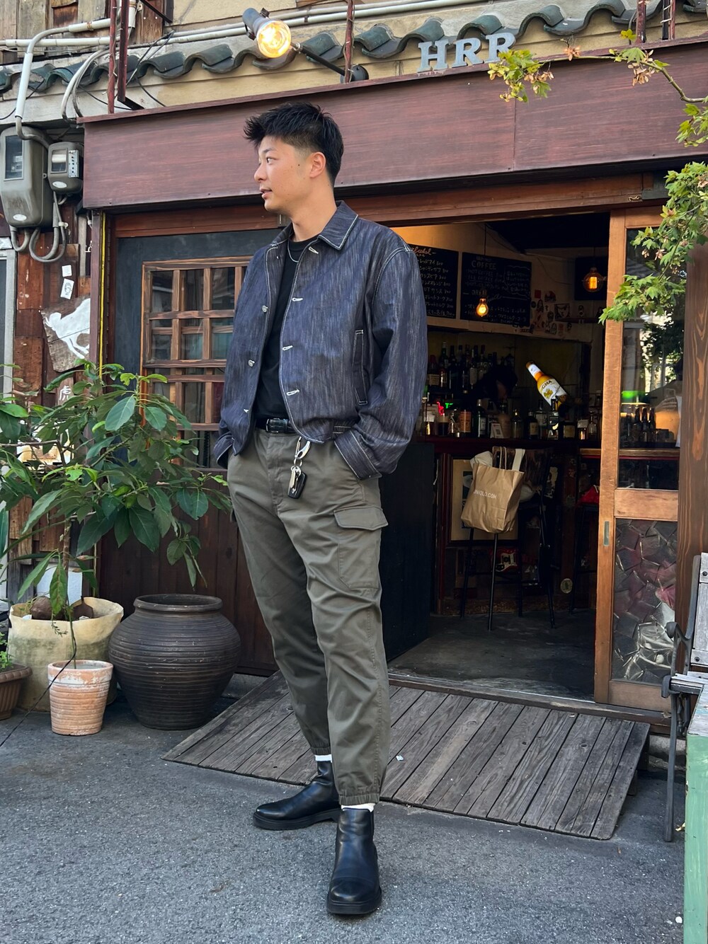 グリーン系のカーゴパンツ、ブラック系のブーツ、ブラック系のベルトを着用したメンズの夏コーディネートの1枚目の写真