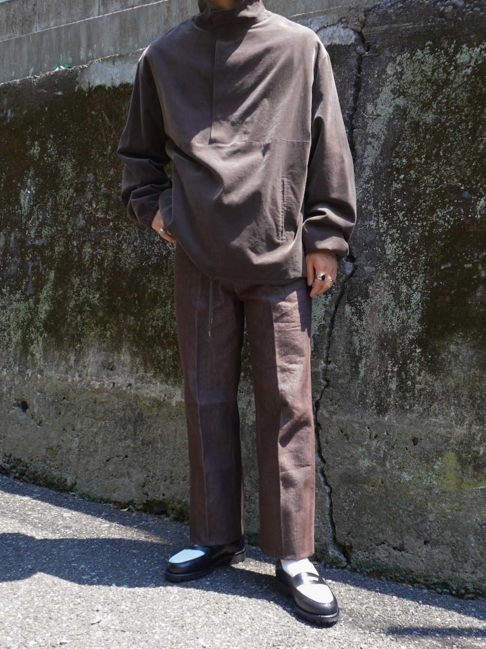 ブラウン系のその他トップス、ブラウン系のデニムパンツ、ブラック系のローファーを着用したメンズの夏コーディネートの1枚目の写真