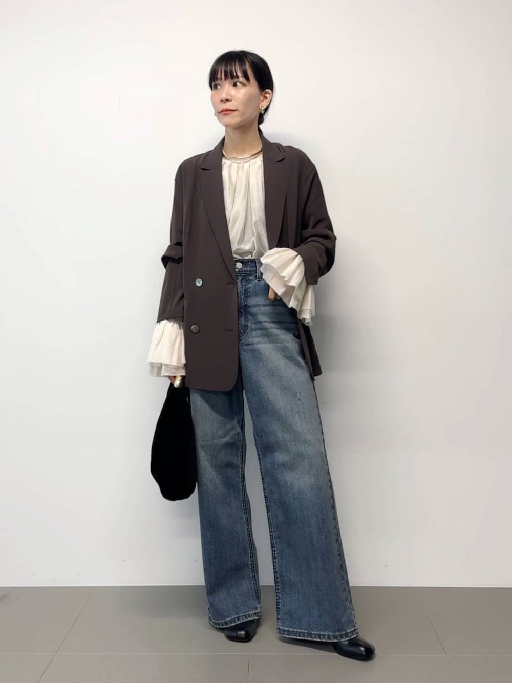 ブラウン系のテーラードジャケット、ブラック系のトートバッグ、その他のチョーカーを着用したレディースの秋コーディネートの1枚目の写真