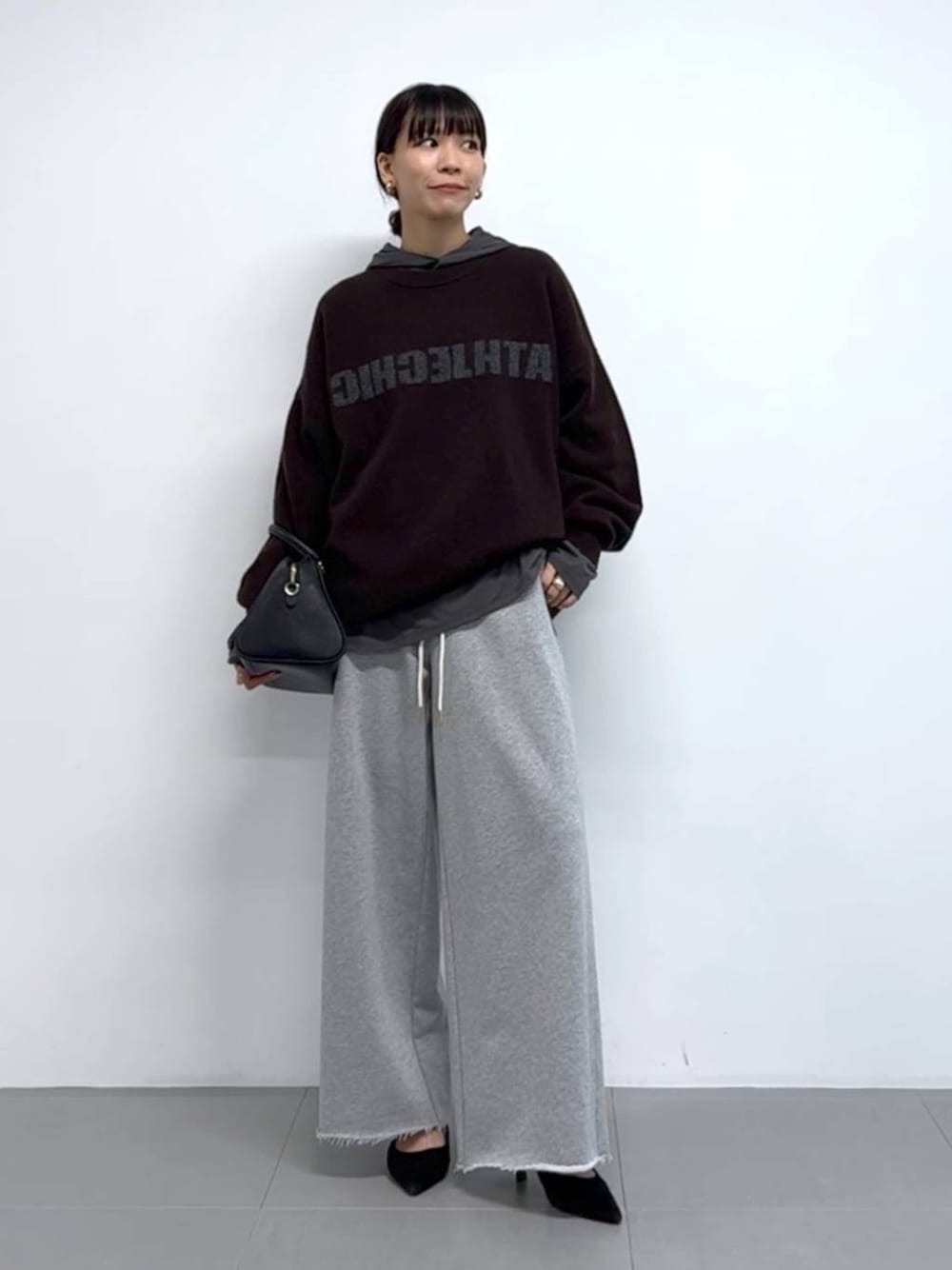 グレー系のTシャツ/カットソー、ブラック系のボストンバッグ、ブラック系のパンプスを着用したレディースの秋コーディネートの1枚目の写真