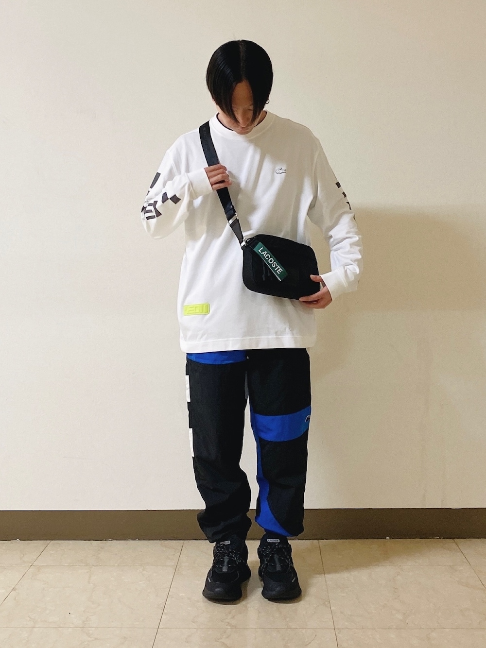 「ロンT、白ロンT、トラックパンツ、スニーカー、黒スニーカー、ショルダーバッグ、ラコステ」｜「LACOSTEのメンズ L003 0722 1（スニーカー、ブラック系）」を使った、maaashiiiiiiさん（メンズ・167cm）の春コーディネートの1枚目の写真