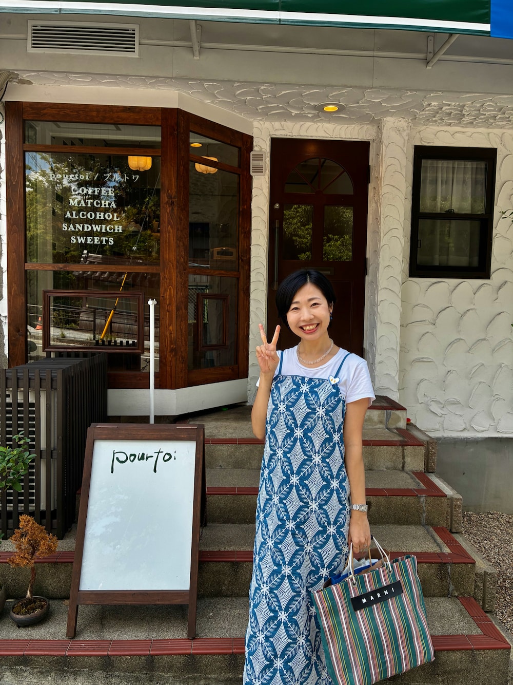 ブルー系のワンピース、ホワイト系のTシャツ/カットソー、グリーン系のかごバッグを着用したレディースの秋コーディネートの1枚目の写真