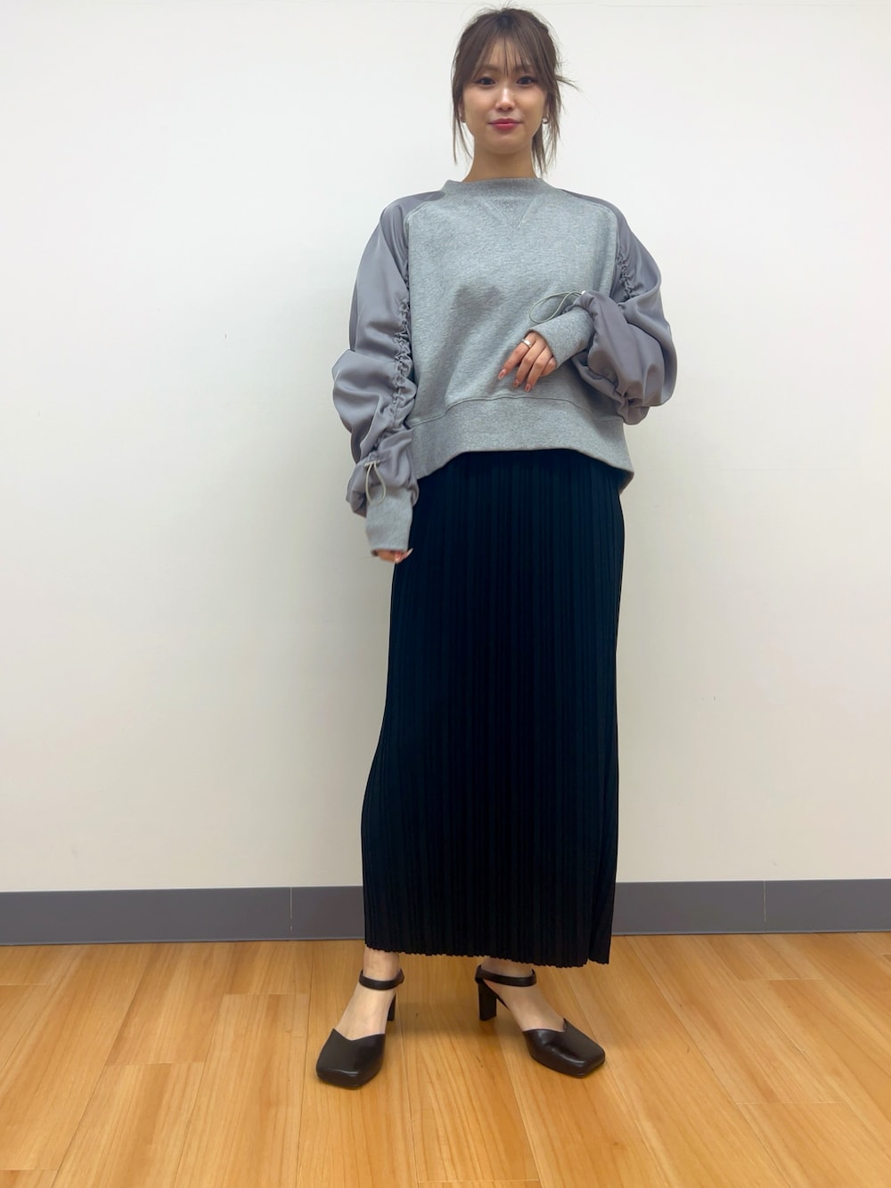 グレー系のTシャツ/カットソー、ブラック系のスカートを着用したレディースの冬コーディネートの1枚目の写真