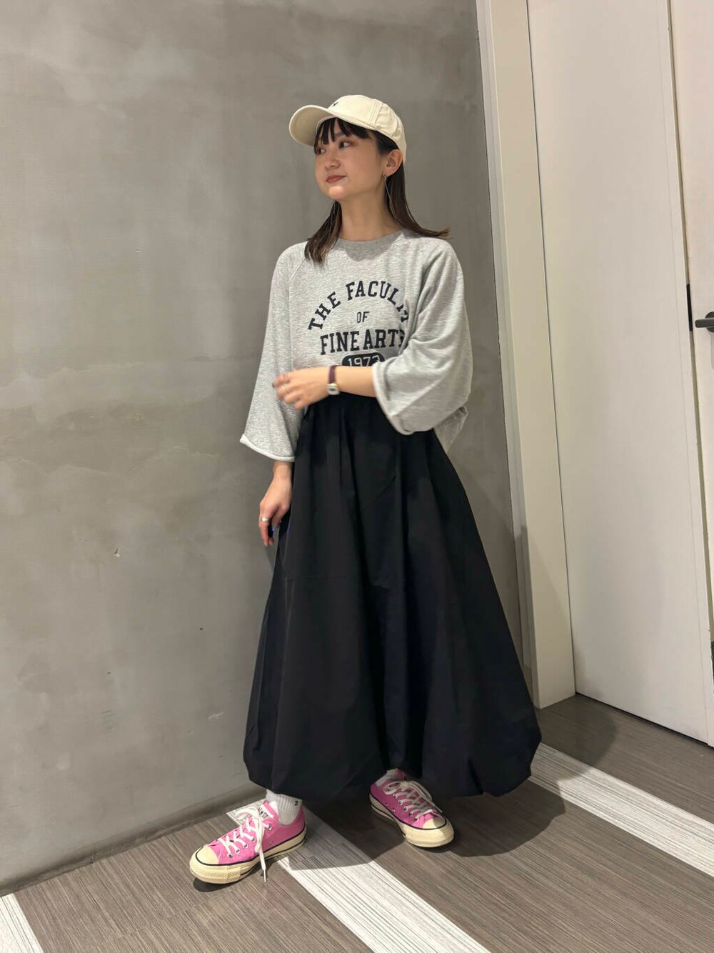グレー系のTシャツ/カットソー、ブラック系のその他パンツ、ホワイト系のキャップを着用したレディースの秋コーディネートの1枚目の写真