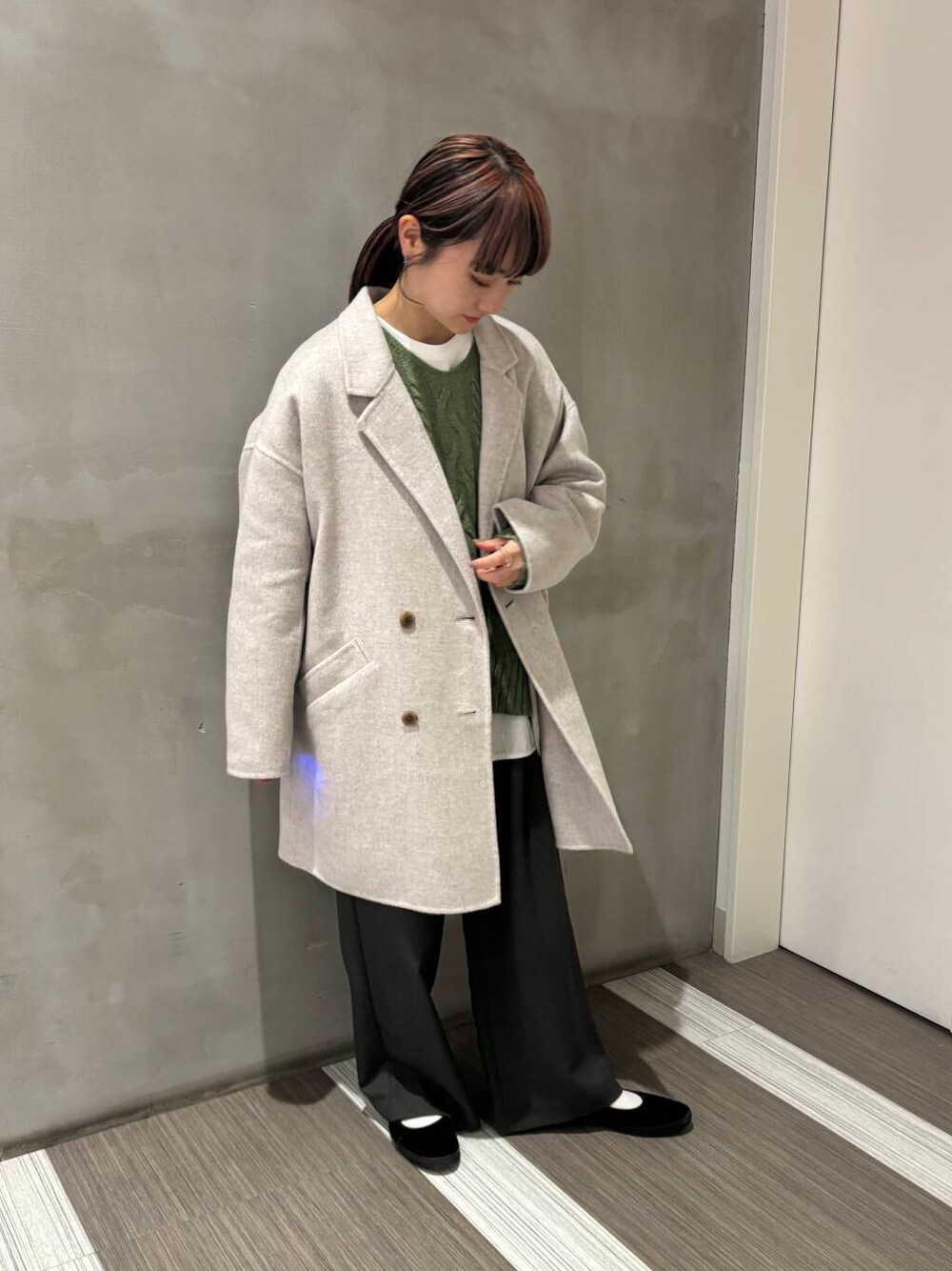 ベージュ系のその他アウター、グリーン系のニット/セーター、グレー系のその他パンツを着用したレディースの秋コーディネートの1枚目の写真