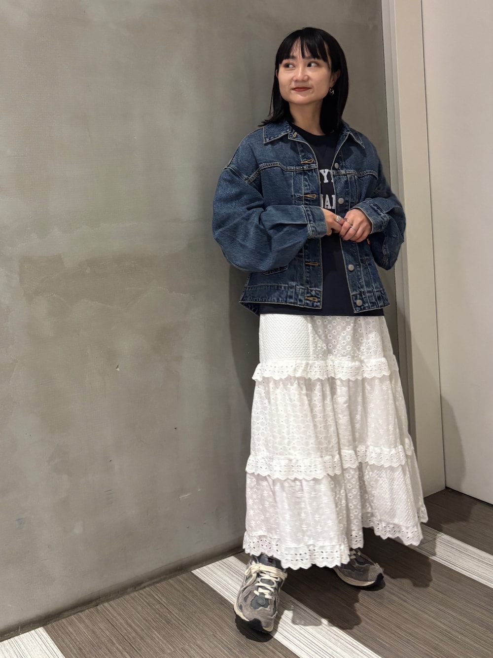 ブルー系のデニムジャケット、グレー系のTシャツ/カットソー、ホワイト系のスカートを着用したレディースの秋コーディネートの1枚目の写真