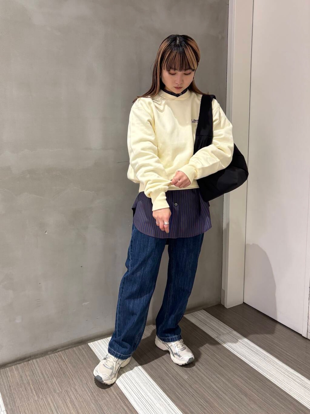 ブルー系のTシャツ/カットソー、ブルー系のデニムパンツ、ブラック系のトートバッグを着用したレディースの冬コーディネートの1枚目の写真