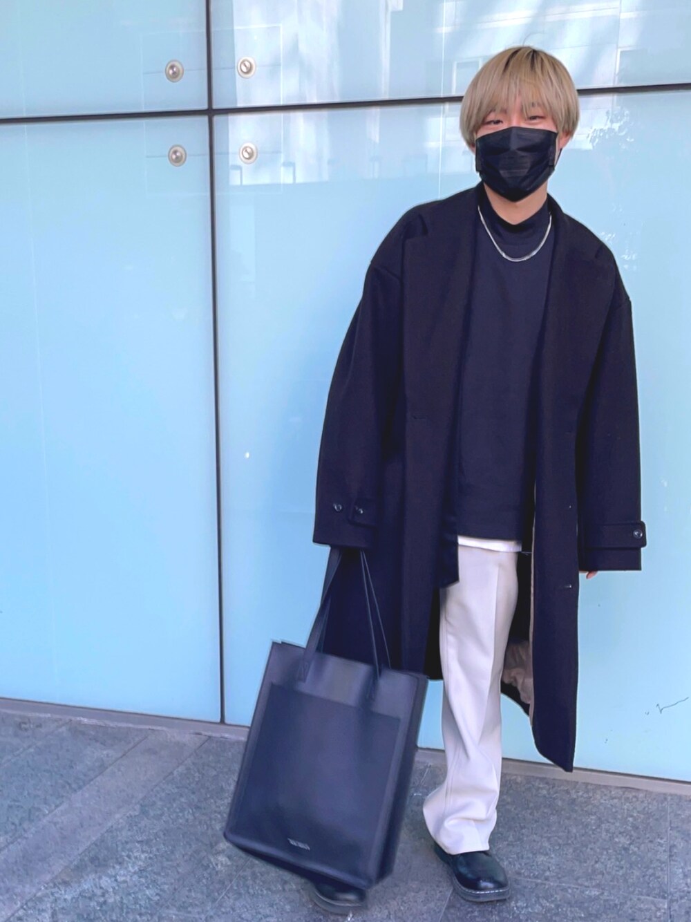 ホワイト系のパンツ、ブラック系のTシャツ/カットソー、ブラック系のトートバッグを着用したメンズの冬コーディネートの1枚目の写真