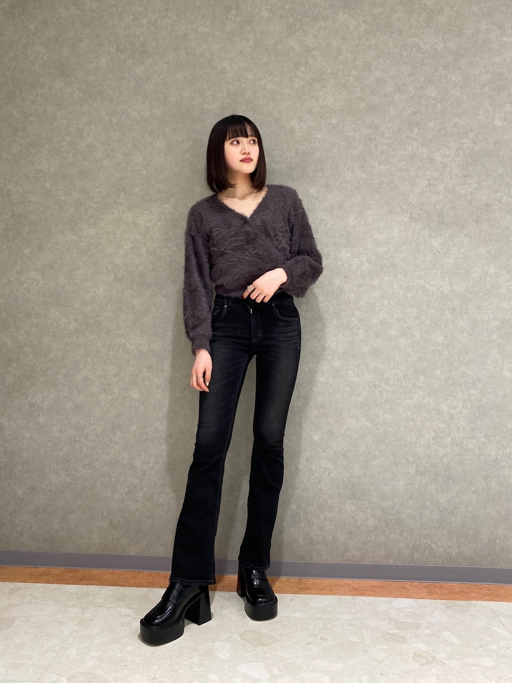 ブラック系のデニムパンツ、グレー系のニット/セーターを着用したレディースの冬コーディネートの1枚目の写真