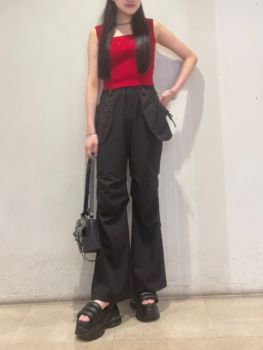 ブラック系のハンドバッグ、ブラック系のその他パンツ、レッド系のTシャツ/カットソーを着用したレディースの夏コーディネートの1枚目の写真
