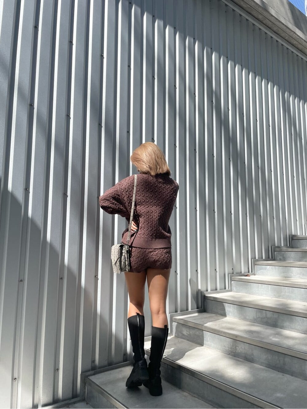 ブラウン系のその他パンツ、ブラック系のブーツ、ブラウン系のニット/セーターを着用したレディースの秋コーディネートの1枚目の写真