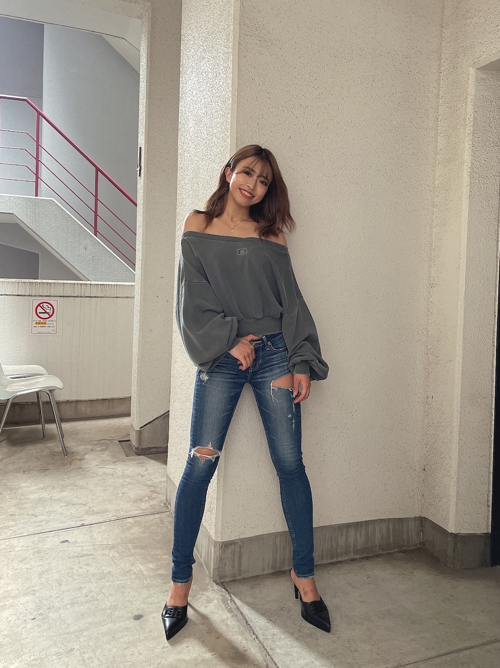 グレー系のスウェット、ブルー系のデニムパンツ、ブラック系のパンプスを着用したレディースの夏コーディネートの1枚目の写真