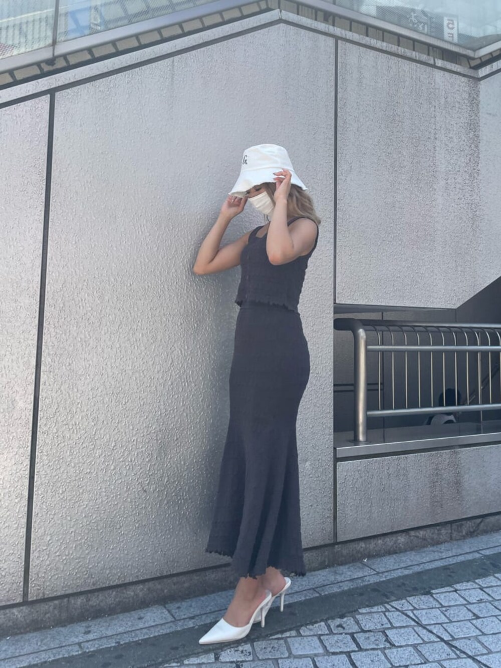 ホワイト系のパンプス、グレー系のスカート、グレー系のタンクトップを着用したレディースの夏コーディネートの1枚目の写真