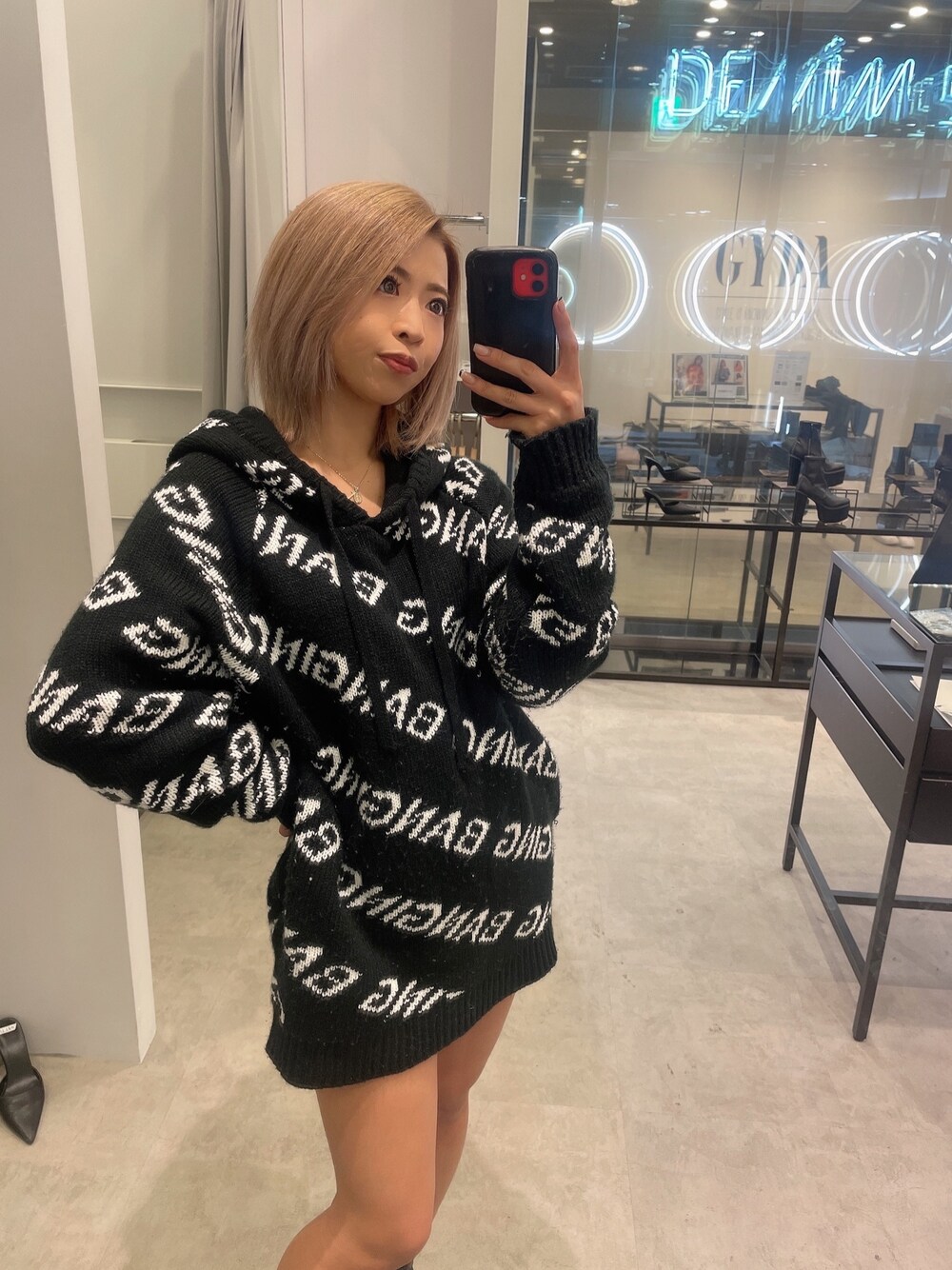 ブラック系のニット/セーター、ブラック系のブーツを着用したレディースの冬コーディネートの1枚目の写真