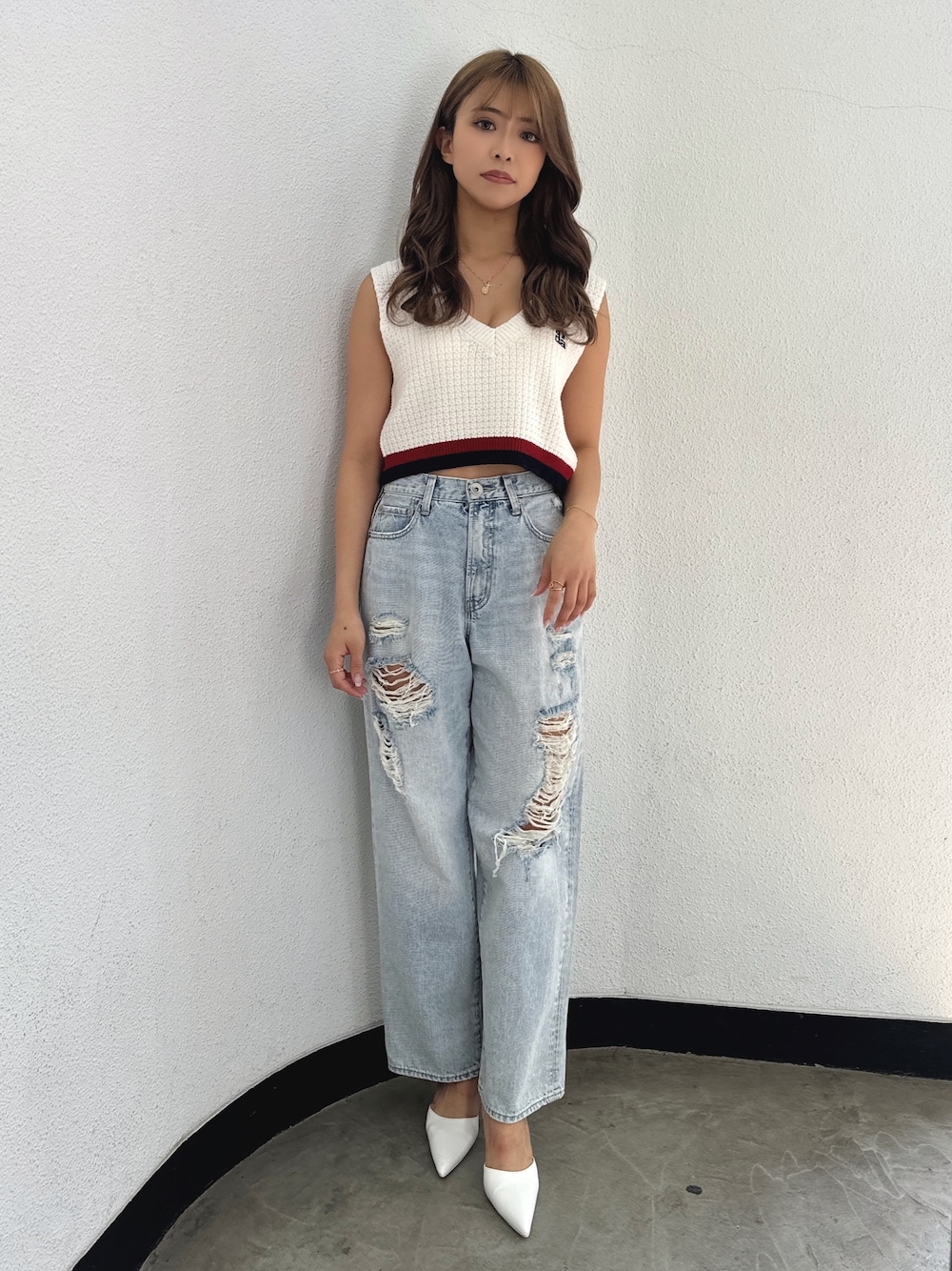 ホワイト系のニット/セーター、ブルー系のデニムパンツ、ホワイト系のパンプスを着用したレディースの春コーディネートの1枚目の写真