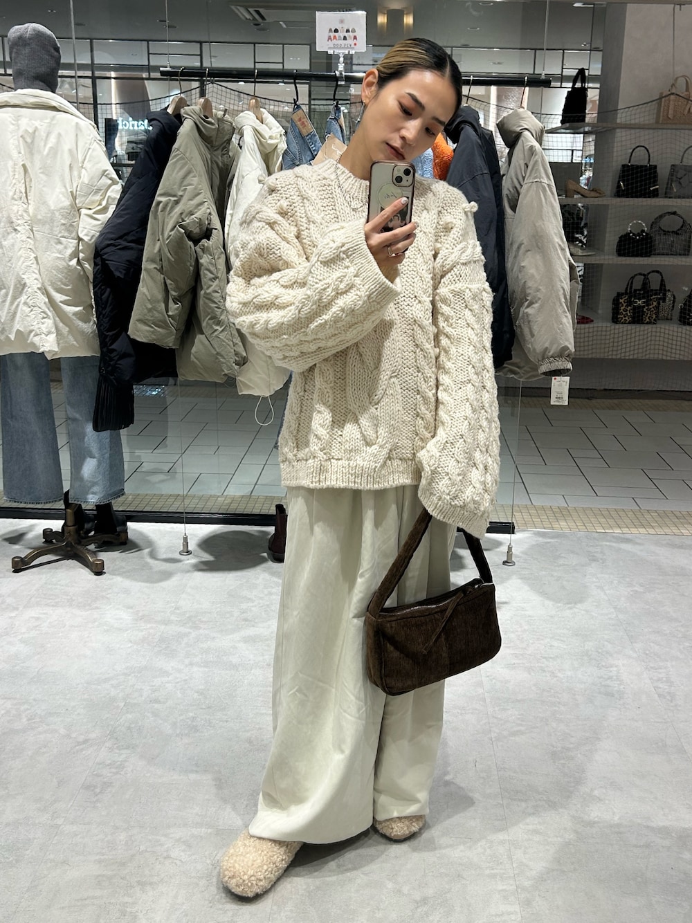 ホワイト系のニット/セーター、ホワイト系のその他パンツ、ブラウン系のハンドバッグを着用したレディースの冬コーディネートの1枚目の写真