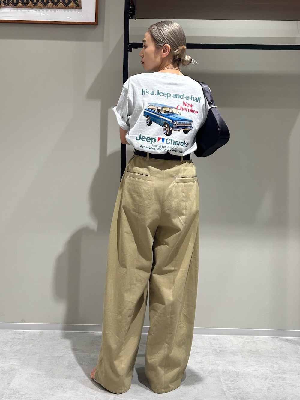 ベージュ系のチノパンツ、グレー系のTシャツ/カットソー、ブラック系のハンドバッグを着用したレディースの夏コーディネートの1枚目の写真