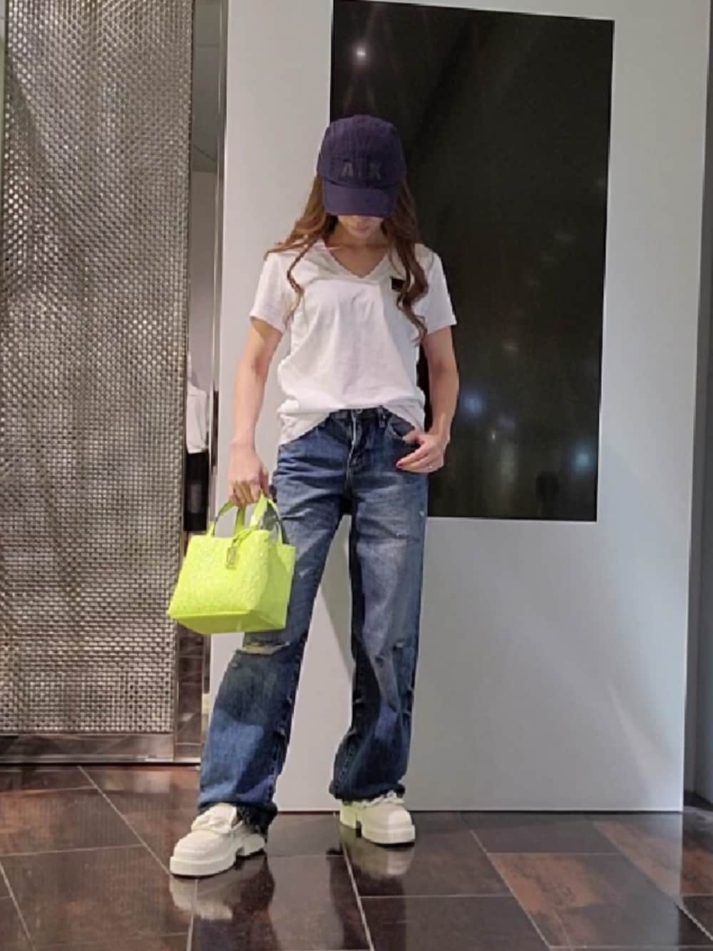 ブルー系のデニムパンツ、ホワイト系のローファー、ホワイト系のTシャツ/カットソーを着用したレディースの春コーディネートの1枚目の写真