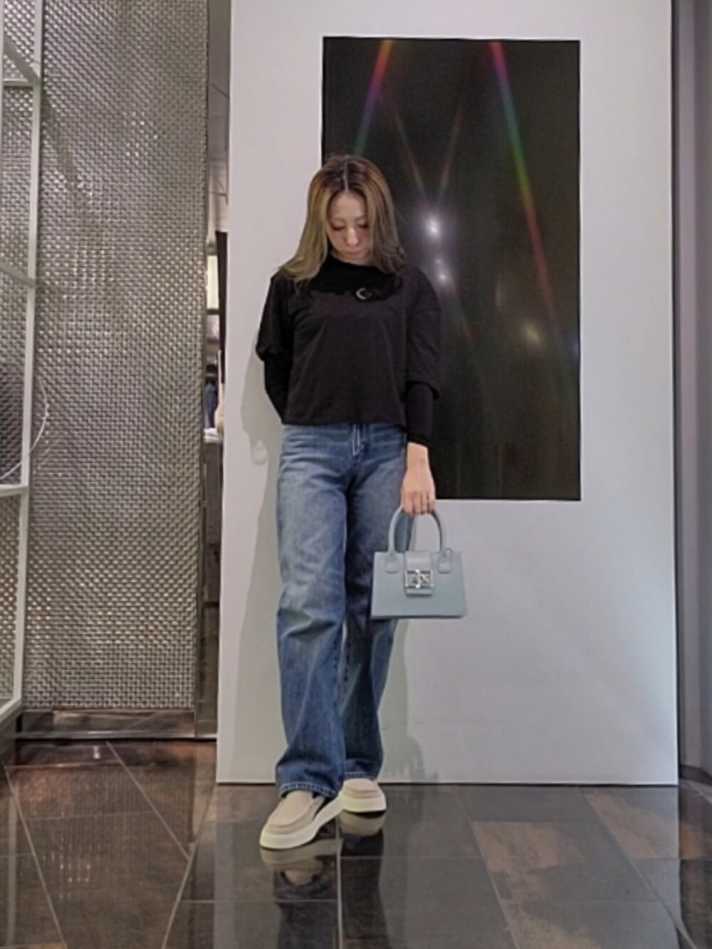 ブラック系のTシャツ/カットソー、ブラック系のハンドバッグ、ブルー系のデニムパンツを着用したレディースの夏コーディネートの1枚目の写真