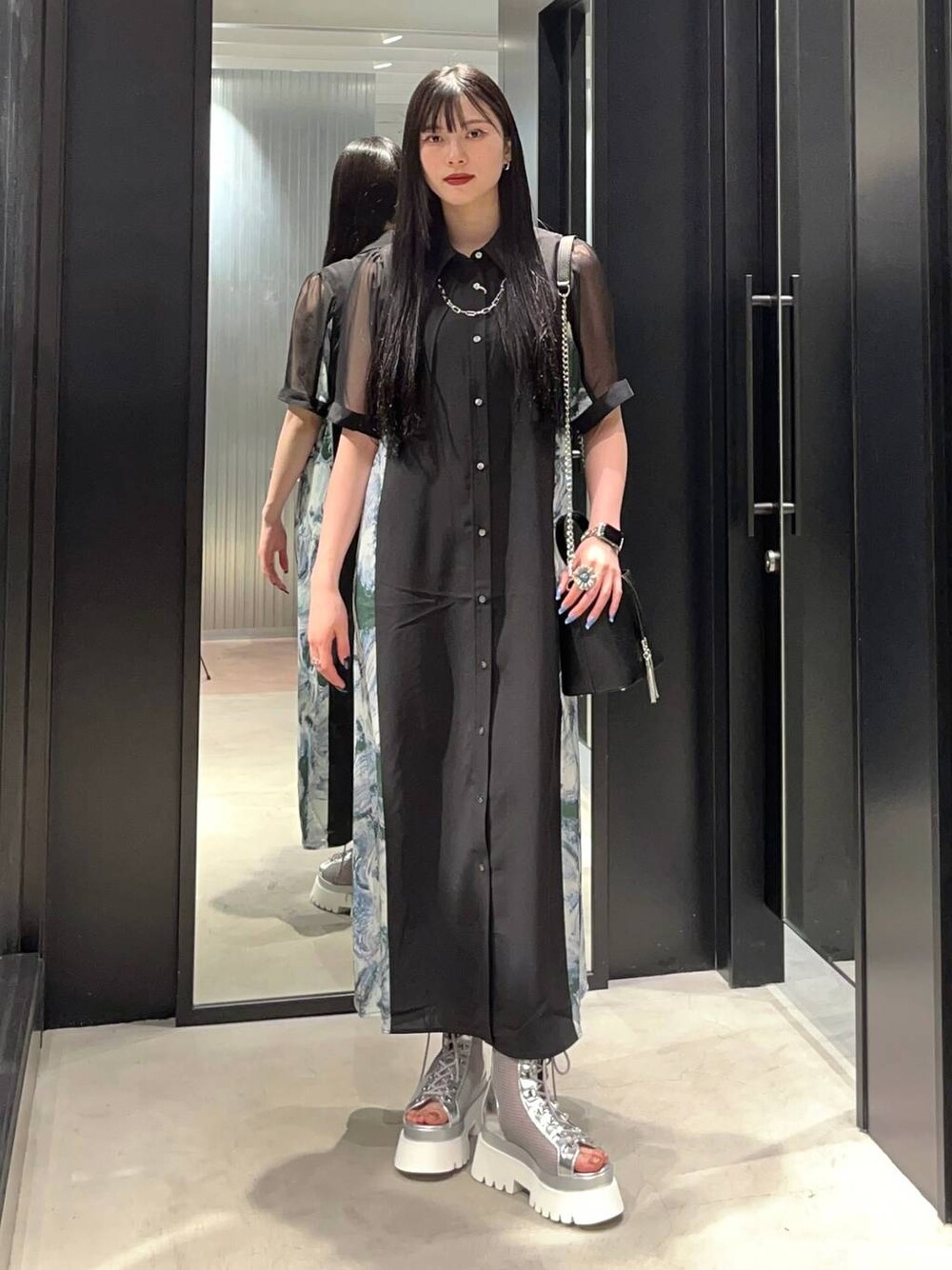 シルバー系のサンダル、グリーン系のワンピース、ブラック系のショルダーバッグを着用したレディースの春コーディネートの1枚目の写真