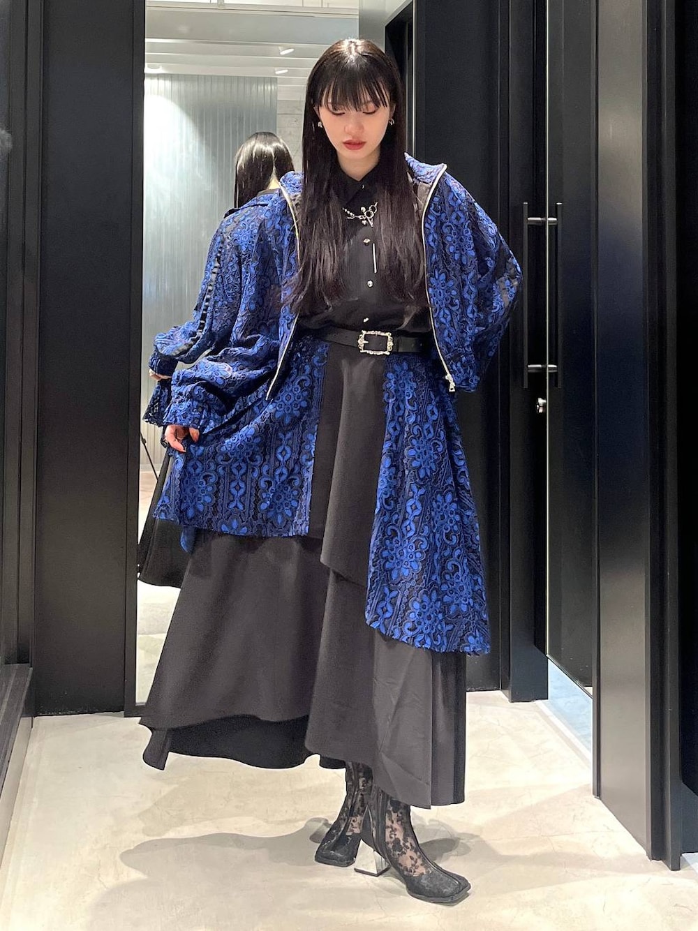 ブルー系のブルゾン、ブラック系のブーツ、ブルー系のスカートを着用したレディースの春コーディネートの1枚目の写真