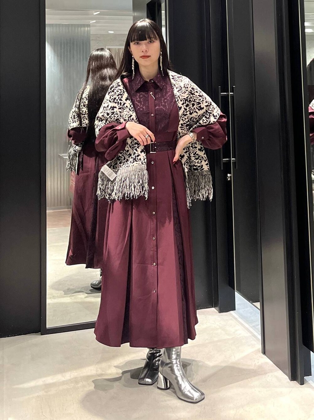 シルバー系のブーツ、レッド系のワンピース、ブラック系のマフラーを着用したレディースの秋コーディネートの1枚目の写真