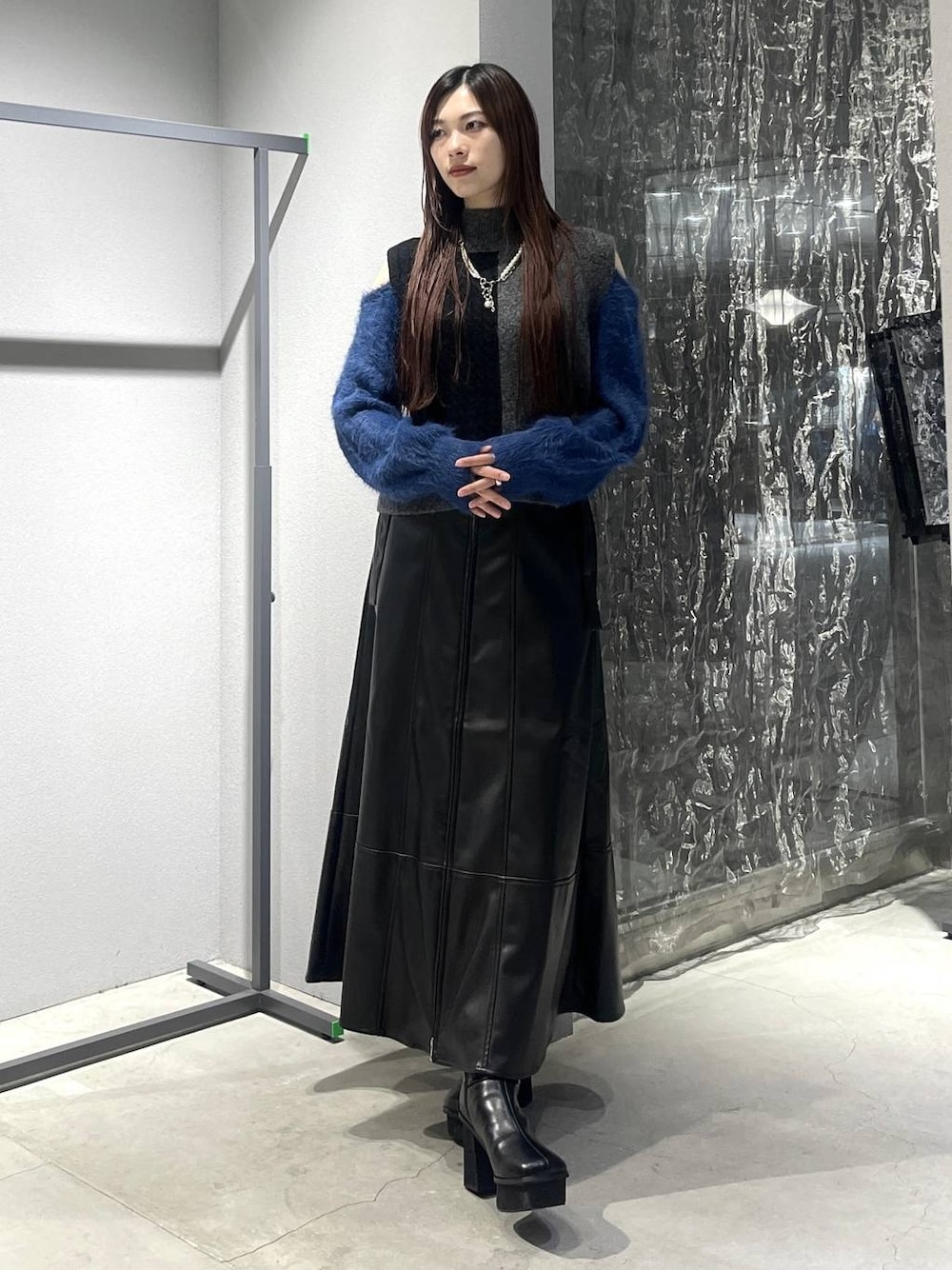 ブラック系のブーツ、ブラック系のニット/セーター、ブラック系のスカートを着用したレディースの秋コーディネートの1枚目の写真